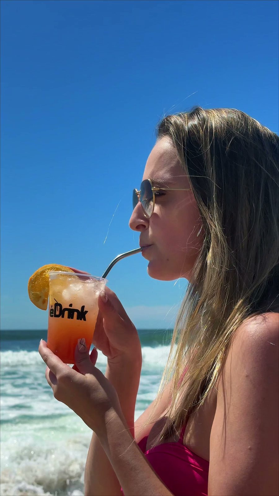 Mulher tomando um drink E-Drink na praia