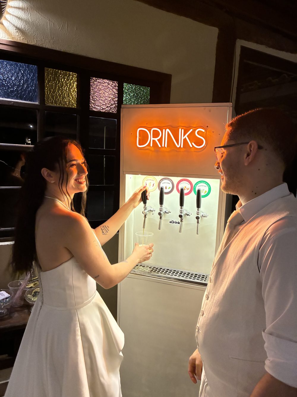 Noivos se servindo de drinks no totem durante o casamento