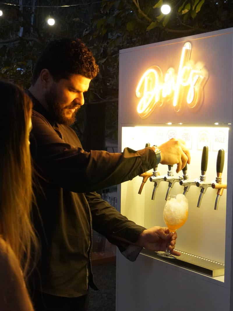 João Paulo Perciliano servindo um drink no totem E-Drink durante um evento