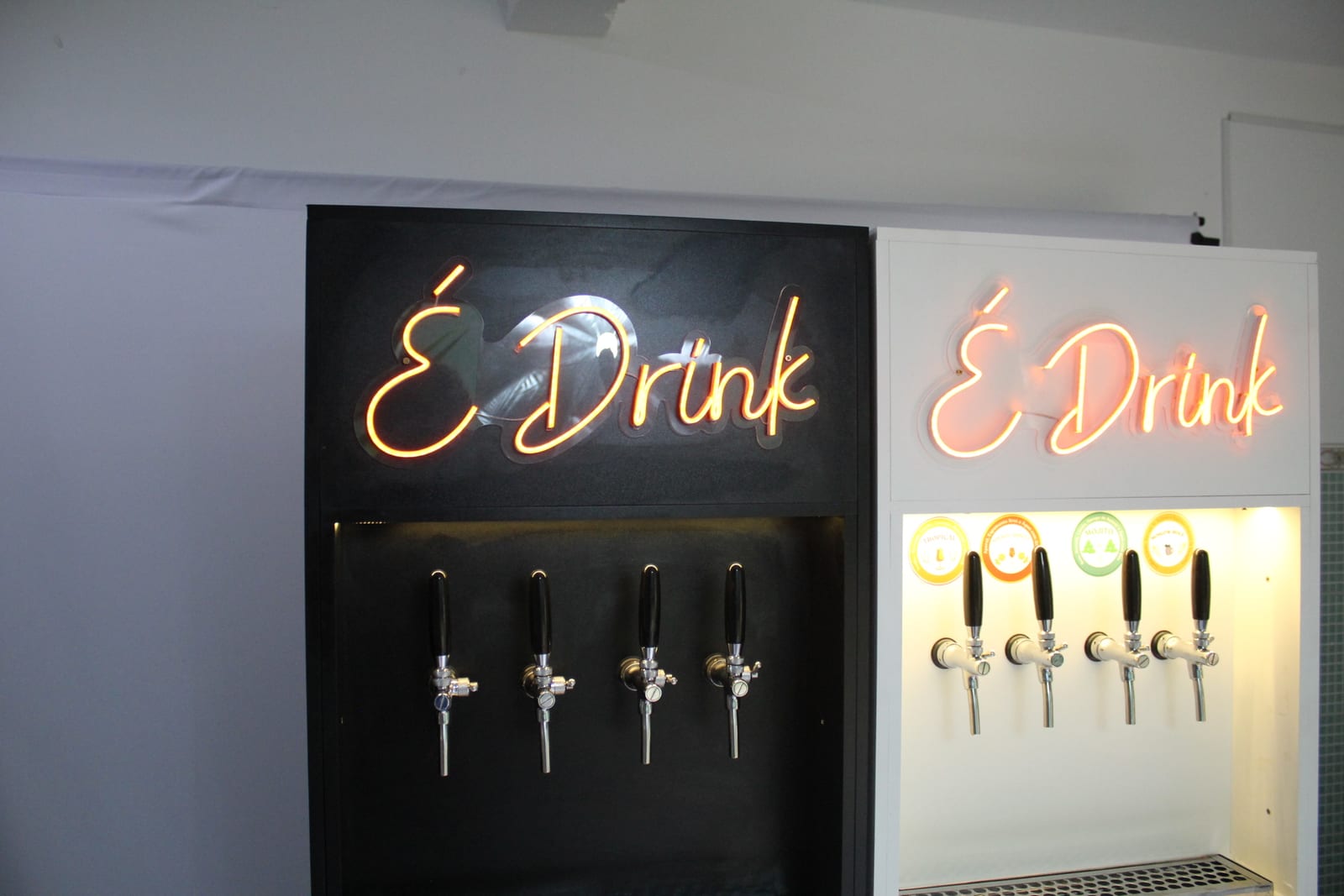 Totens E-Drink preto e branco lado a lado, com neon e torneiras iluminadas